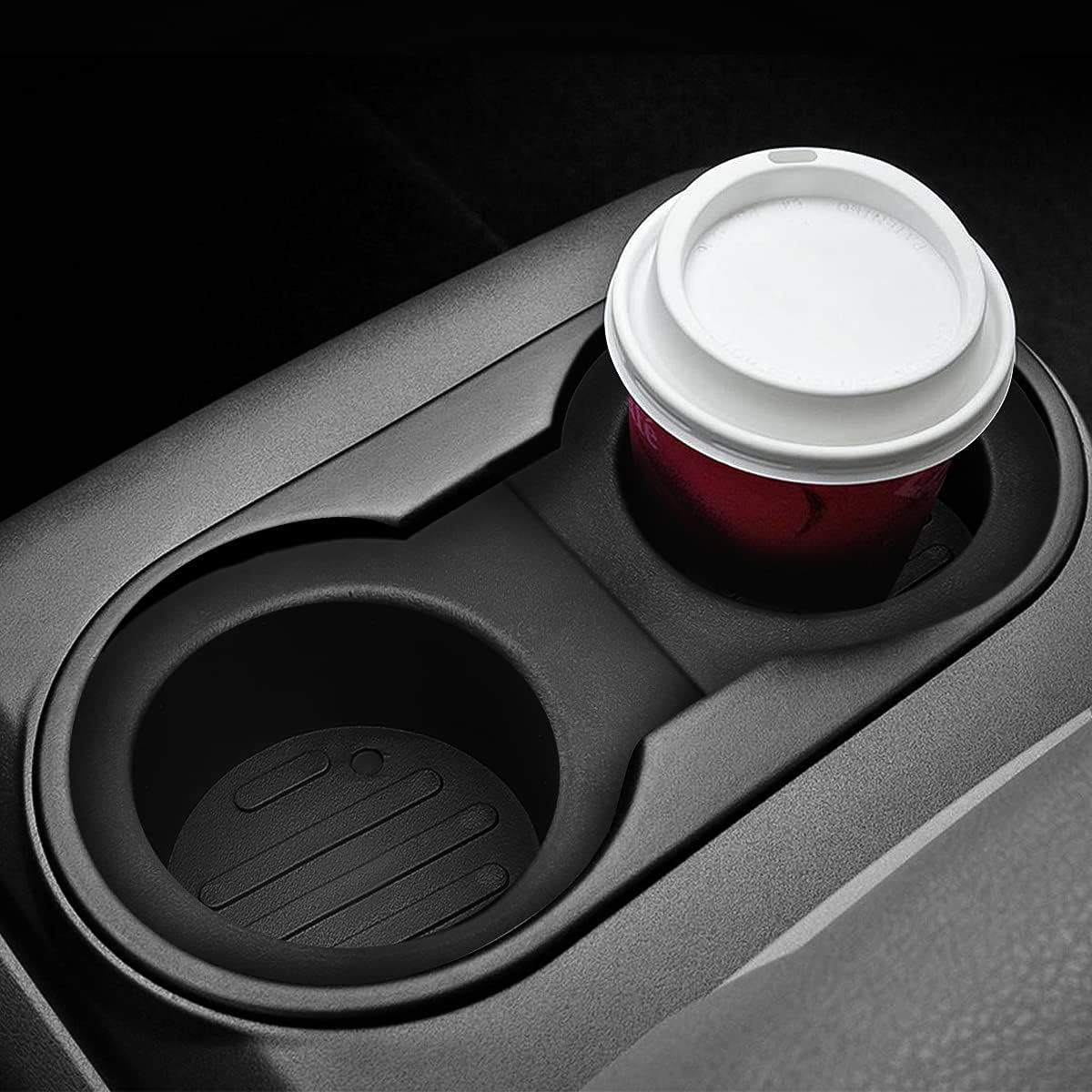 Highlights the product's cup holder feature, showing its ability to securely hold a coffee cup in a vehicle.