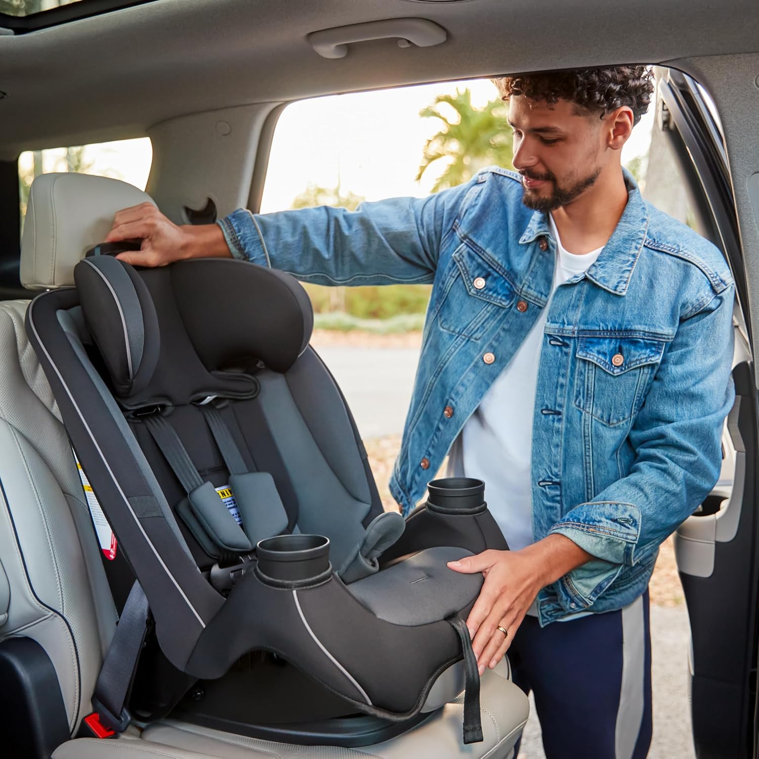 Shows the ease of installing and using the car seat in a real-world context, demonstrating its practicality for parents. Highlights the convenient cup holder feature of the car seat, emphasizing…