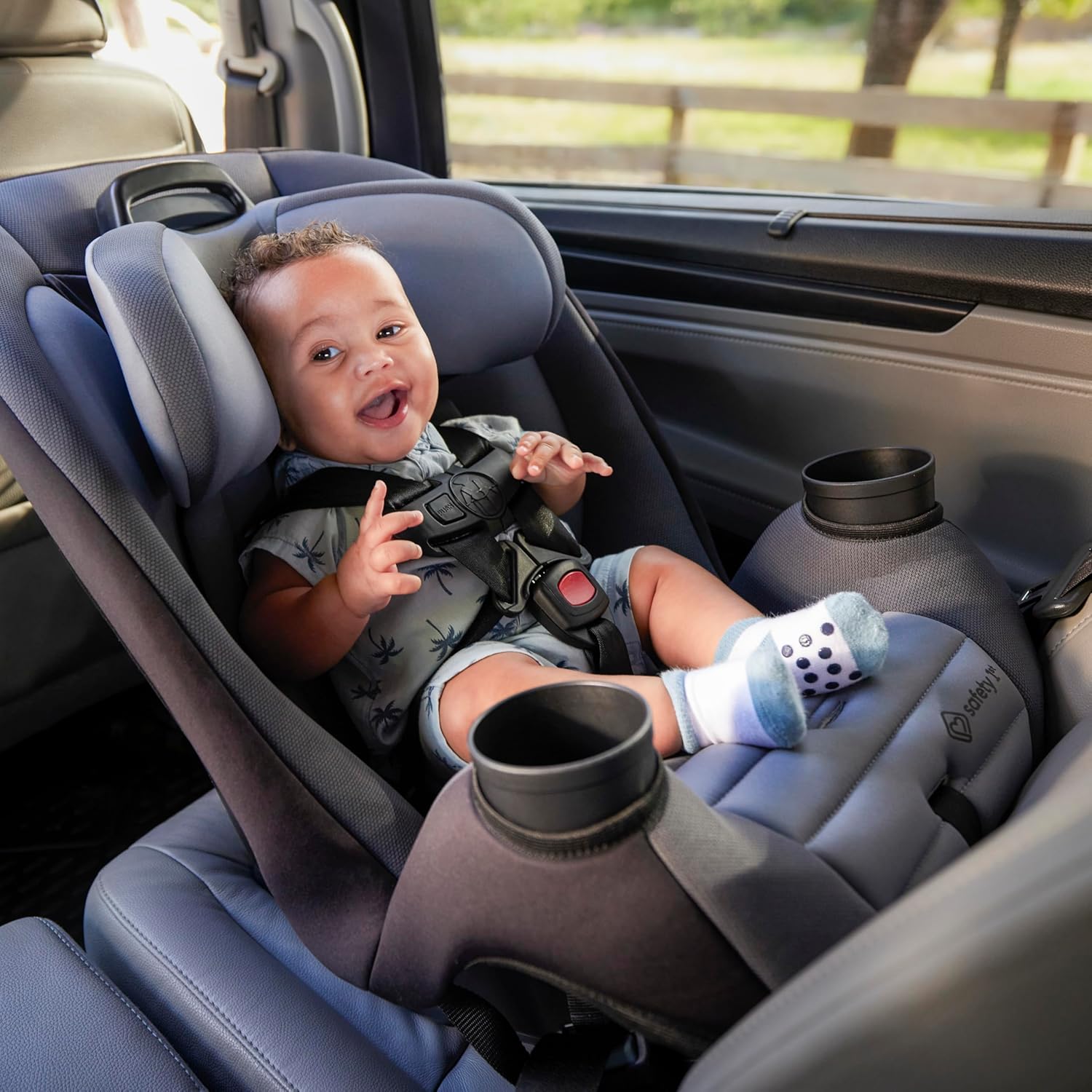 Shows a happy baby securely fastened in a car seat, demonstrating the product's safety and comfort features for young children during car travel.