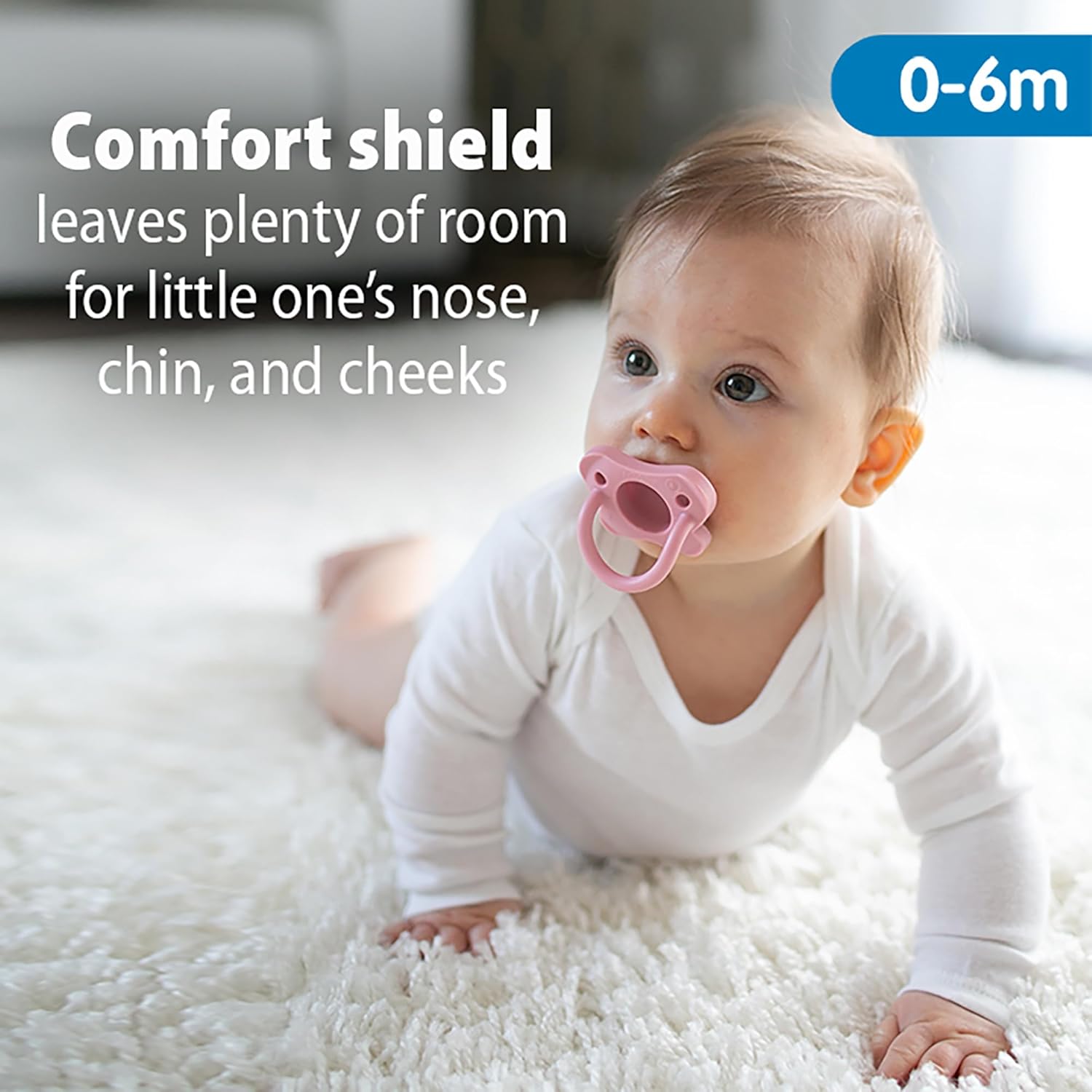 Highlights the pacifier's comfort shield feature that provides space for the baby's nose, chin, and cheeks, ensuring a comfortable fit.
