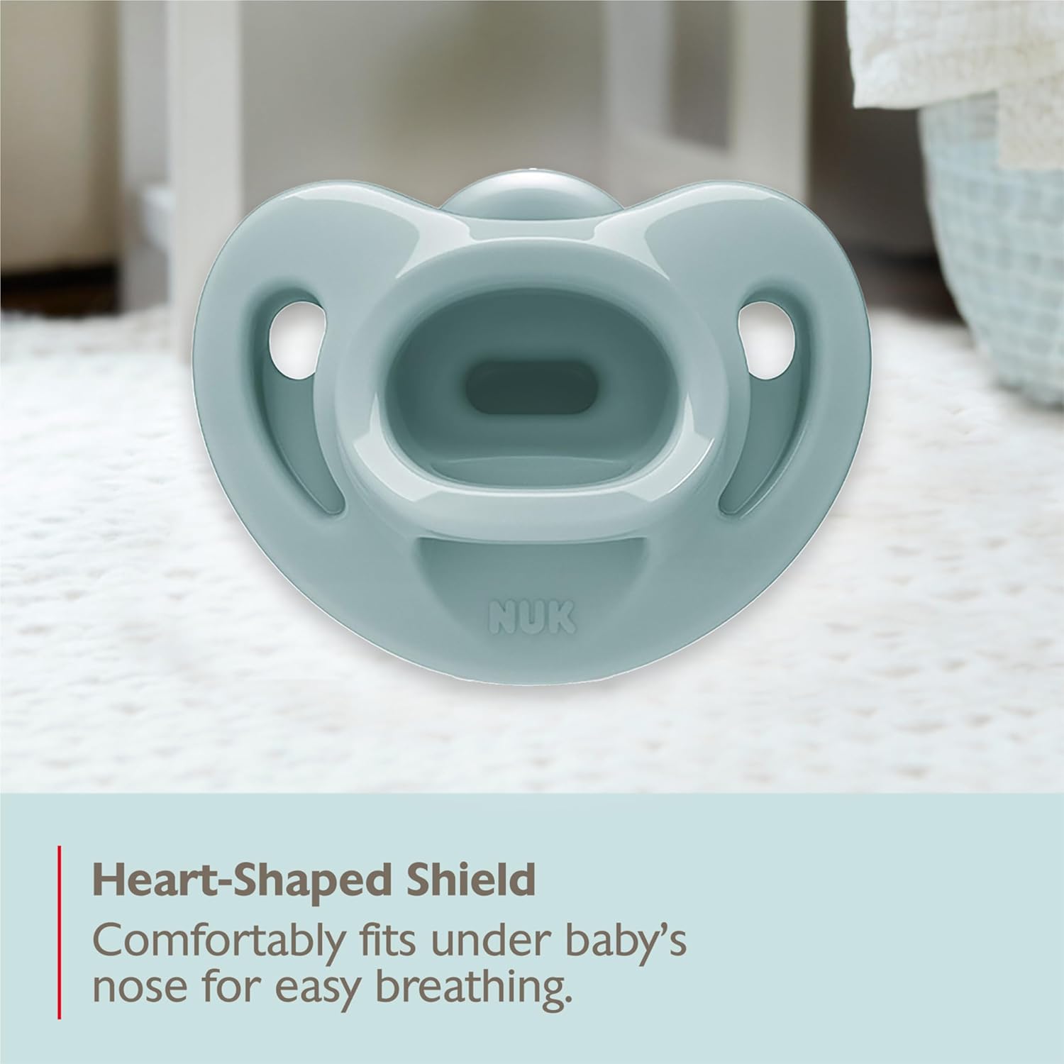 Highlights the pacifier's heart-shaped shield design that allows for easy breathing, emphasizing comfort and safety for the baby.