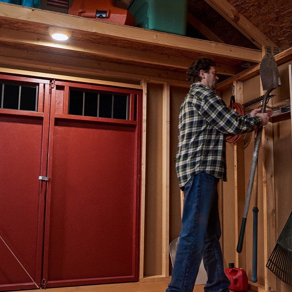 Demonstrates the convenience and functionality of the motion-activated light in a garage or storage setting.