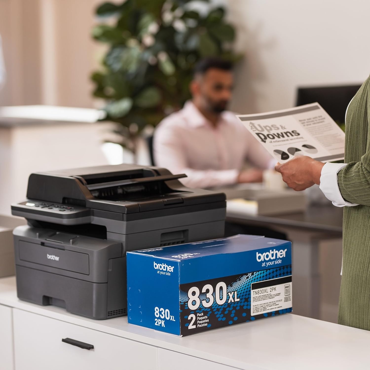 Shows the printer in use in a real office setting to demonstrate its suitability for professional environments. Highlights that the product comes with toner cartridges, emphasizing the complete…