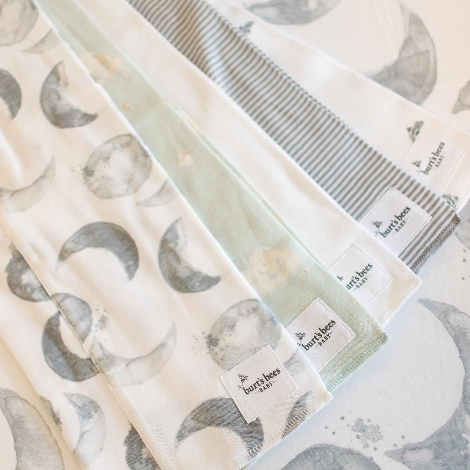Showcases the variety of fabric patterns included in the product set, likely burp cloths or baby blankets.
