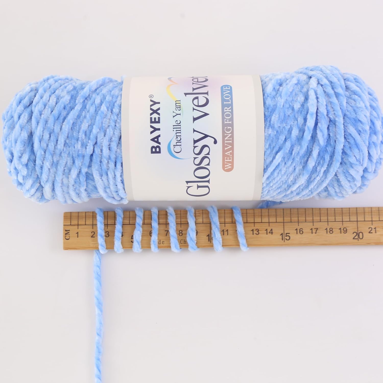 Demonstrates the thickness of the yarn using a ruler for scale, helping customers understand the product's texture and gauge.