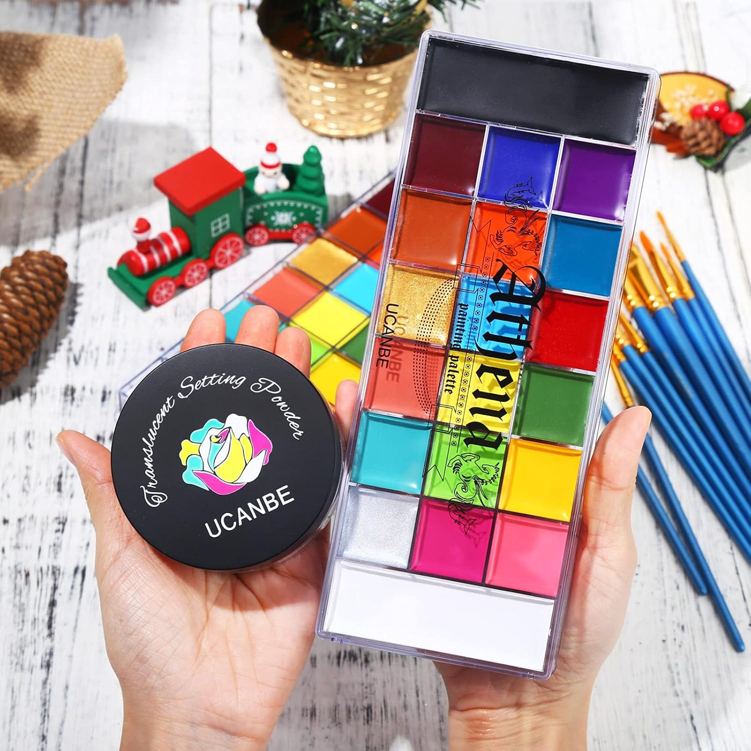 Showcases a colorful makeup palette in a festive holiday setting to appeal to shoppers looking for seasonal beauty products. Displays the complete product set, including the colorful eyeshadow…