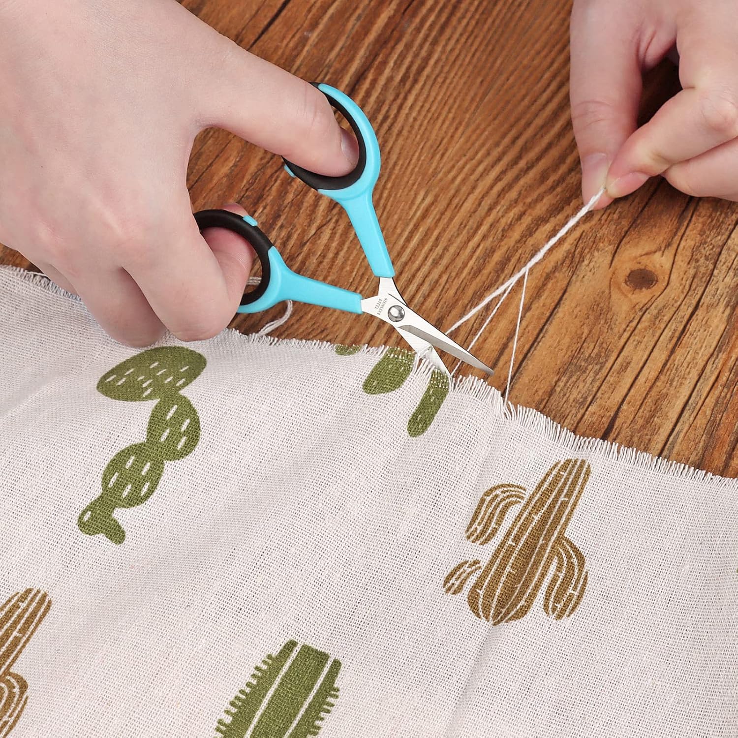 Demonstrates how to properly cut fabric using scissors, showing the correct technique for precise cutting.