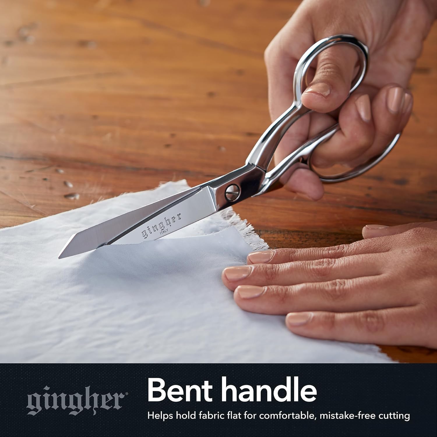 Highlights the scissors' bent handle feature, which helps hold fabric flat for comfortable and precise cutting.